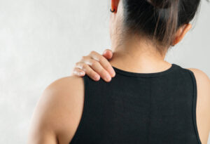 Lady holding painful shoulder needing trigger point injections