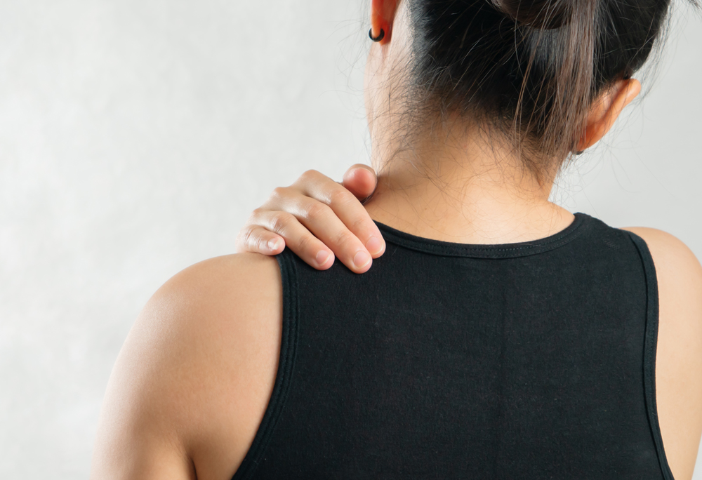 Lady holding painful shoulder needing trigger point injections